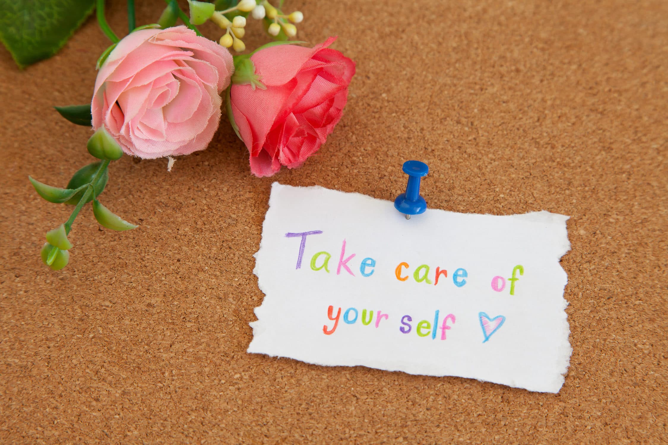 Take care of your self message - Hand writing text on cork board